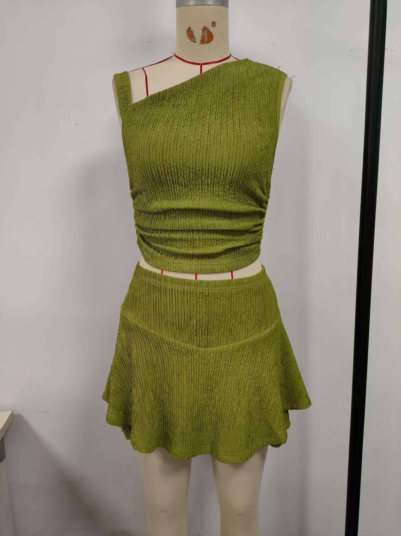 Green, suit skirt, top with one side exposed shoulder, short skirt hem