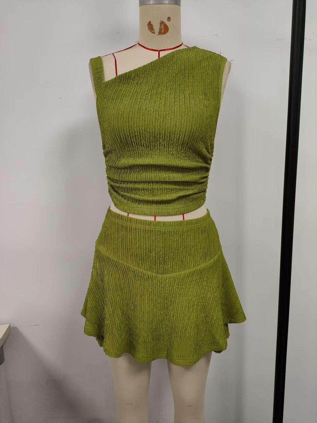 Green, suit skirt, top with one side exposed shoulder, short skirt hem